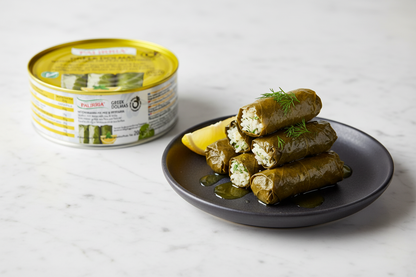 Close-up of Palirria hand-rolled dolmades with lemon and olive oil on white marble
