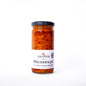 Jar of red pepper spread with a visible label on a white background